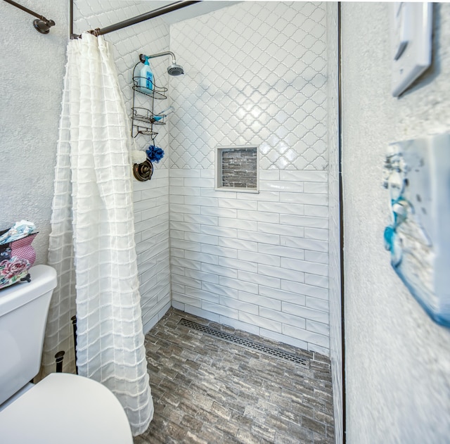 624 10th Ave N, Lake Worth Beach, FL 33460 - bathroom with a tile shower, a textured wall, and brick patterned floors