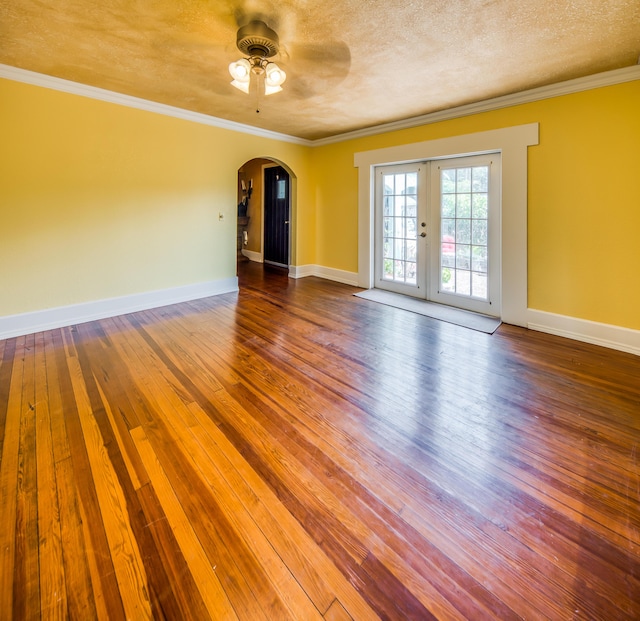 624 10th Ave N, Lake Worth Beach, FL 33460 - empty room featuring arched walkways, wood-type flooring, a ceiling fan, french doors, and crown molding