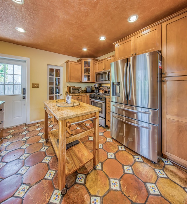 624 10th Ave N, Lake Worth Beach, FL 33460 - kitchen featuring appliances with stainless steel finishes, recessed lighting, glass insert cabinets, and brown cabinetry