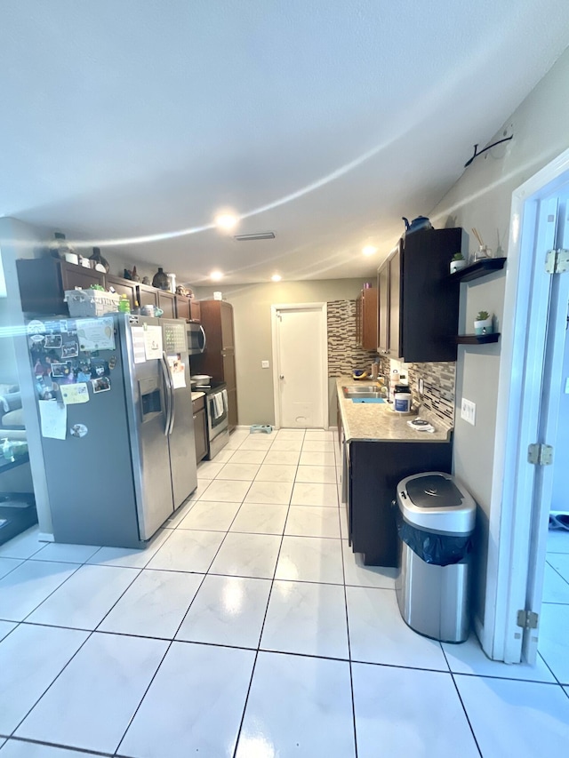 409 NE Oleander Ave, Port Saint Lucie, FL 34952 - kitchen featuring stainless steel appliances, decorative backsplash, open shelves, and light tile patterned flooring