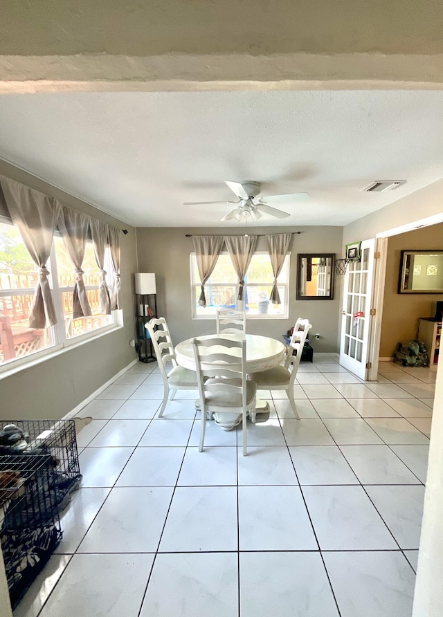 409 NE Oleander Ave, Port Saint Lucie, FL 34952 - dining room featuring healthy amount of natural light, a ceiling fan, light tile patterned flooring, and french doors