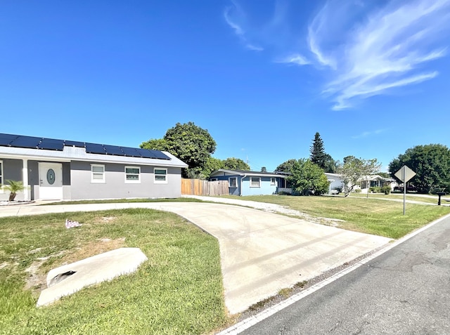 409 NE Oleander Ave, Port Saint Lucie, FL 34952 - single story home with roof mounted solar panels, stucco siding, and driveway