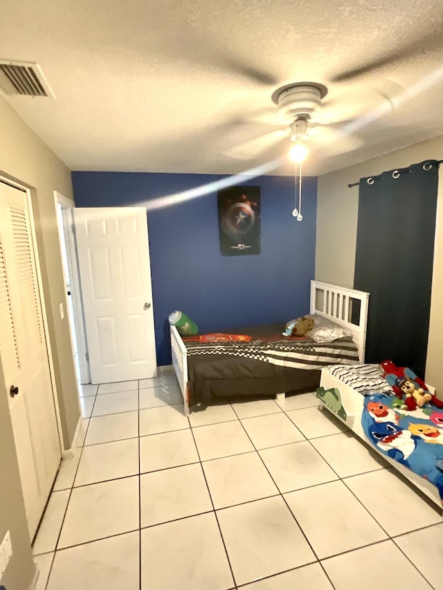 409 NE Oleander Ave, Port Saint Lucie, FL 34952 - tiled bedroom featuring a textured ceiling, a ceiling fan, and a closet