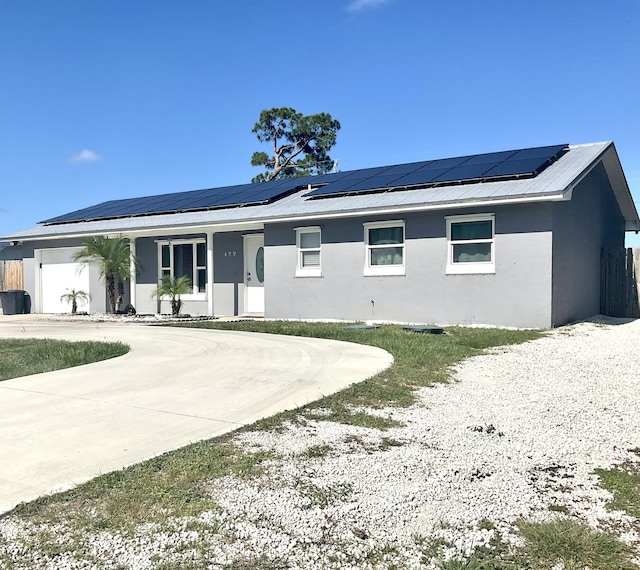 409 NE Oleander Ave, Port Saint Lucie, FL 34952 - view of front of property with a porch, roof mounted solar panels, stucco siding, and curved driveway