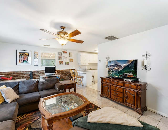 918 Grace Ave, Lake Worth, FL 33461 - living room featuring light tile patterned floors, a ceiling fan, and brick wall