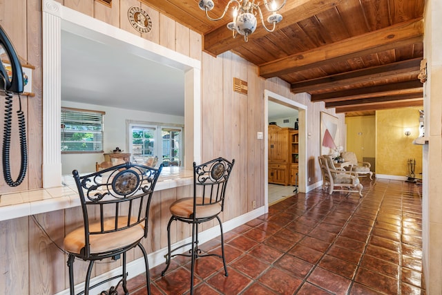 918 Grace Ave, Lake Worth, FL 33461 - dining area featuring a wooden ceiling with exposed beams, a chandelier, wood walls, and dark tile patterned floors