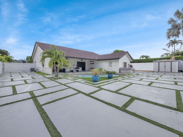 1598 SW 19th St, Boca Raton, FL 33486 - rear view of house with a storage unit, a patio, a tile roof, stucco siding, and a fenced backyard