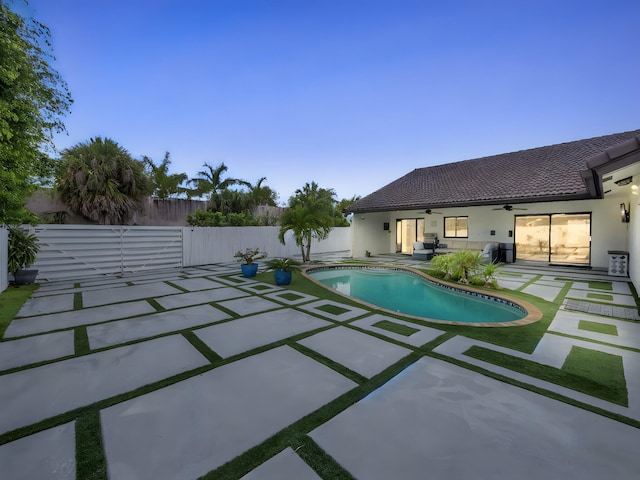 1598 SW 19th St, Boca Raton, FL 33486 - pool at dusk featuring ceiling fan, a patio area, and a fenced backyard