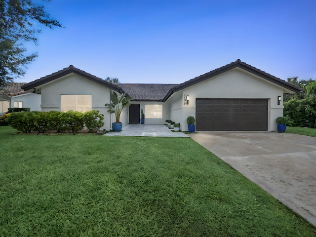 1598 SW 19th St, Boca Raton, FL 33486 - ranch-style house with stucco siding, a front lawn, an attached garage, and concrete driveway