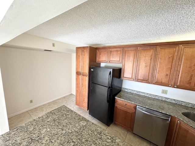 1119 Green Pine Blvd Unit C1, West Palm Beach, FL 33409 - kitchen featuring dishwasher, freestanding refrigerator, brown cabinets, light tile patterned floors, and a textured ceiling