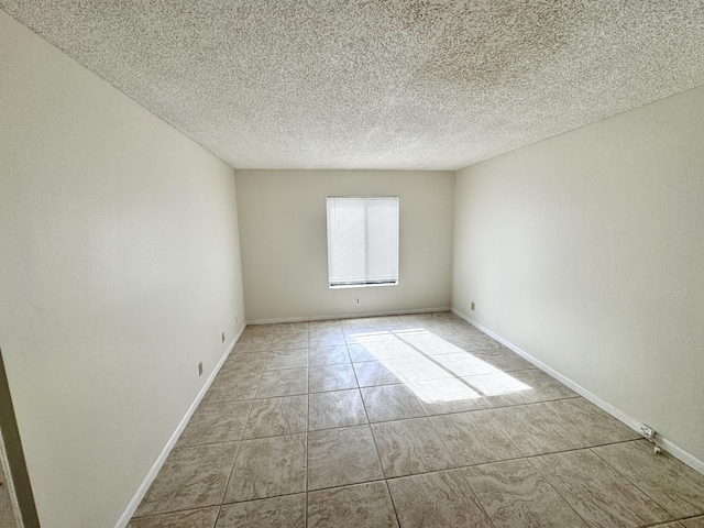 1119 Green Pine Blvd Unit C1, West Palm Beach, FL 33409 - tiled empty room with a textured ceiling and baseboards