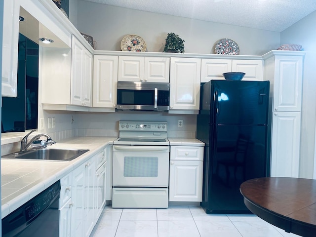 18619 Breezy Palm Way, Boca Raton, FL 33496 - kitchen featuring black appliances, tile counters, white cabinets, and a textured ceiling