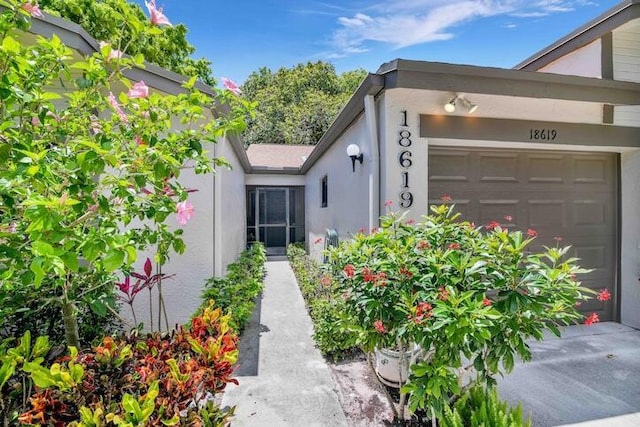 18619 Breezy Palm Way, Boca Raton, FL 33496 - view of exterior entry featuring a garage and stucco siding