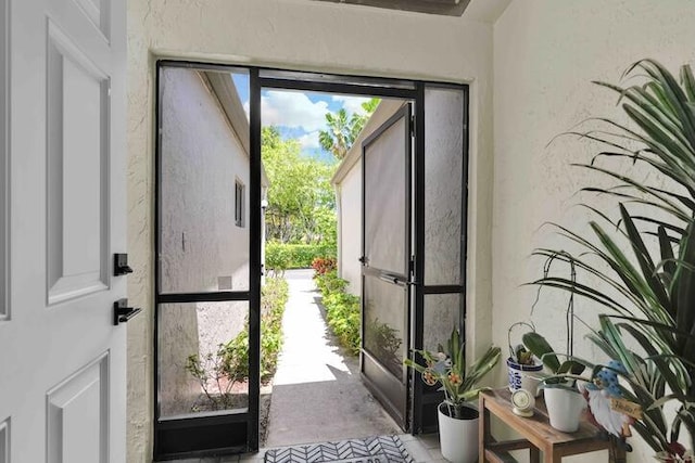 18619 Breezy Palm Way, Boca Raton, FL 33496 - doorway to outside with a textured wall, healthy amount of natural light, and concrete floors
