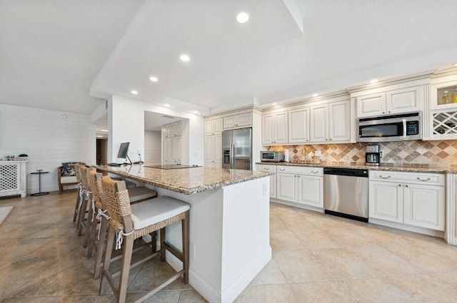 2200 S Ocean Blvd Unit 102, Delray Beach, FL 33483 - kitchen with stainless steel appliances, a breakfast bar area, light stone counters, backsplash, and recessed lighting