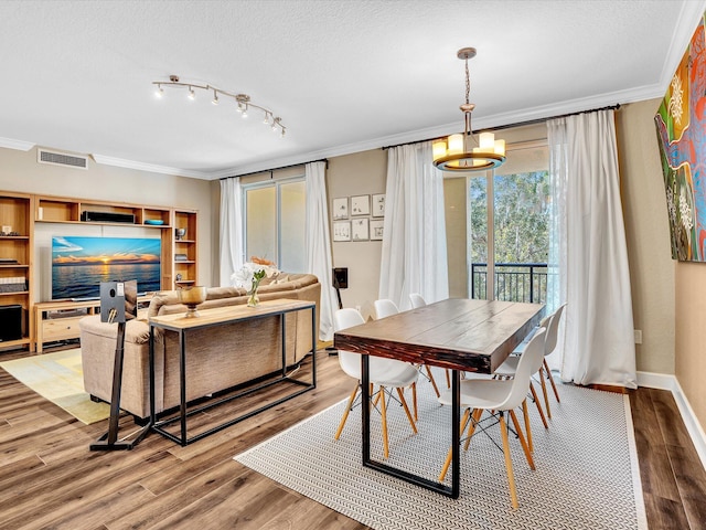 2 Renaissance Way Unit 302, Boynton Beach, FL 33426 - dining space featuring ornamental molding, light wood finished floors, a textured ceiling, and a chandelier