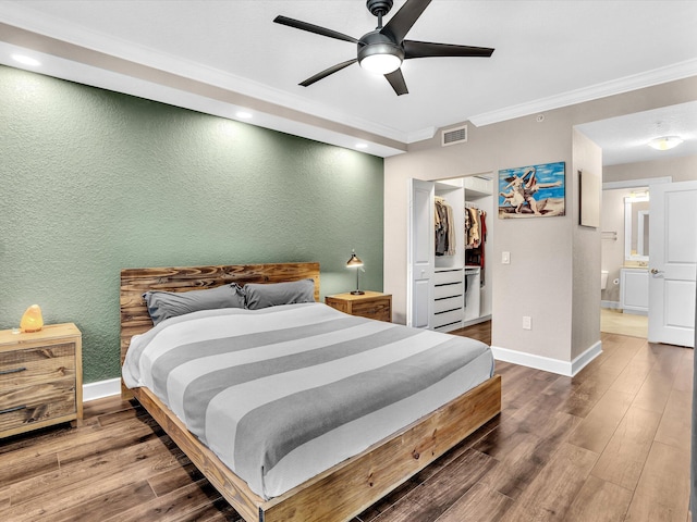 2 Renaissance Way Unit 302, Boynton Beach, FL 33426 - bedroom with ornamental molding, wood finished floors, a textured wall, a ceiling fan, and a spacious closet