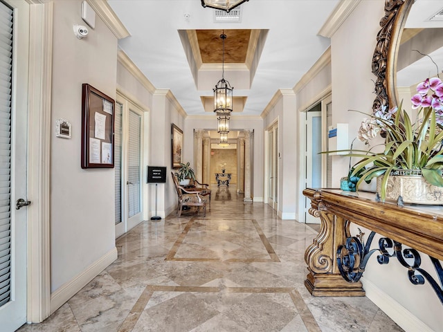 2 Renaissance Way Unit 302, Boynton Beach, FL 33426 - foyer with light marble finish flooring, a chandelier, a raised ceiling, crown molding, and inlaid floor details