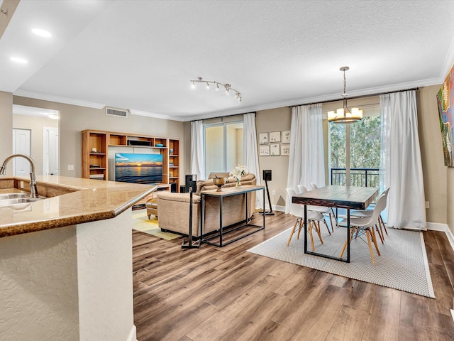 2 Renaissance Way Unit 302, Boynton Beach, FL 33426 - kitchen with wood finished floors, ornamental molding, a chandelier, light stone counters, and decorative light fixtures