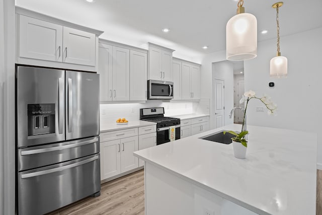 11695 SW Viridian Blvd, Port Saint Lucie, FL 34987 - kitchen featuring appliances with stainless steel finishes, recessed lighting, light wood-type flooring, tasteful backsplash, and light countertops
