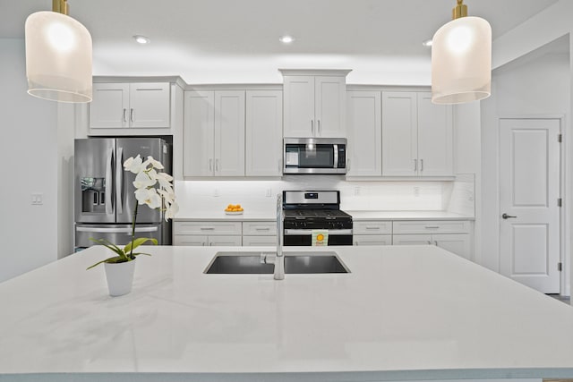 11695 SW Viridian Blvd, Port Saint Lucie, FL 34987 - kitchen with stainless steel appliances, decorative backsplash, light countertops, recessed lighting, and an island with sink