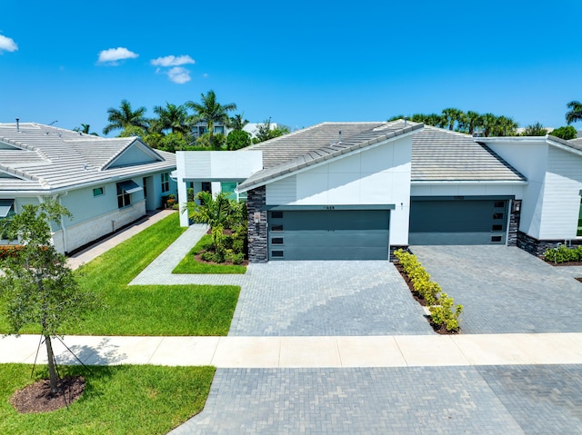 11695 SW Viridian Blvd, Port Saint Lucie, FL 34987 - contemporary house with a tile roof, a garage, stone siding, and a front lawn