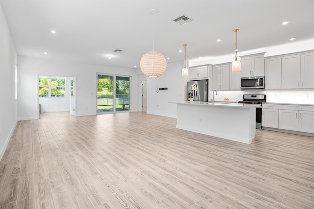 11695 SW Viridian Blvd, Port Saint Lucie, FL 34987 - kitchen featuring stainless steel appliances, open floor plan, recessed lighting, an island with sink, and light wood-type flooring