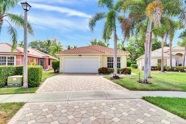 8140 Palm Gate Dr, Boynton Beach, FL 33436 - mediterranean / spanish house with stucco siding, a front lawn, decorative driveway, a tiled roof, and a garage