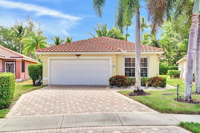 8140 Palm Gate Dr, Boynton Beach, FL 33436 - mediterranean / spanish home with stucco siding, a tile roof, a front lawn, decorative driveway, and a garage