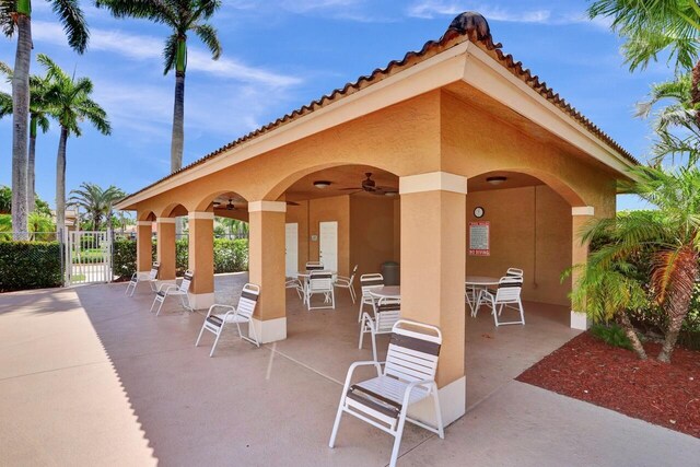 8140 Palm Gate Dr, Boynton Beach, FL 33436 - view of patio featuring outdoor dining area, ceiling fan, and a gate
