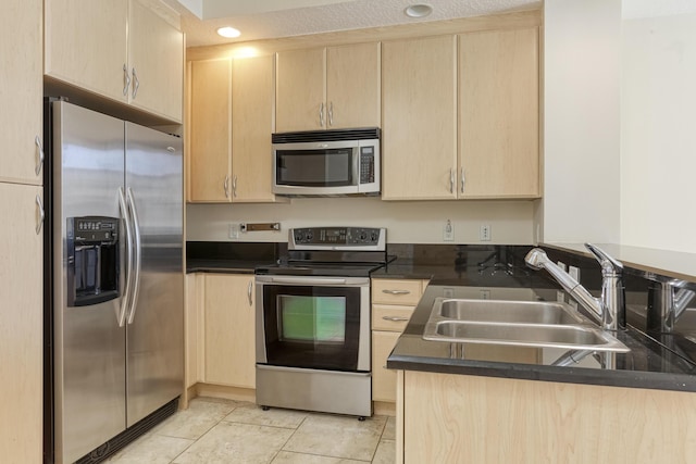 701 S Olive Ave Unit 1208, West Palm Beach, FL 33401 - kitchen featuring appliances with stainless steel finishes, light brown cabinetry, dark countertops, light tile patterned flooring, and a peninsula
