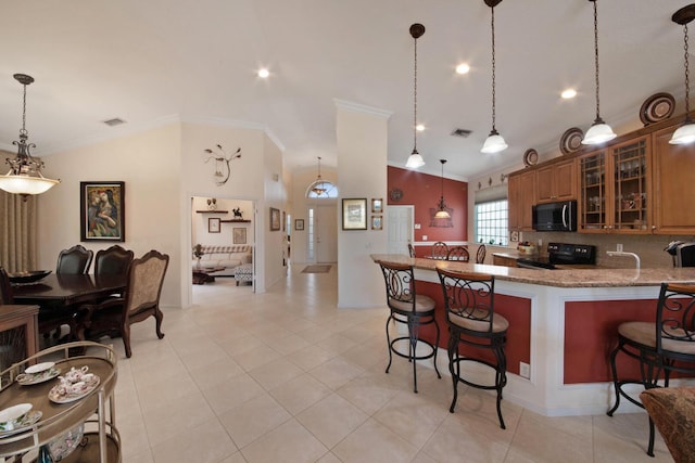 7052 Cataluna Cir, Delray Beach, FL 33446 - kitchen featuring black appliances, crown molding, a kitchen bar, vaulted ceiling, and brown cabinetry