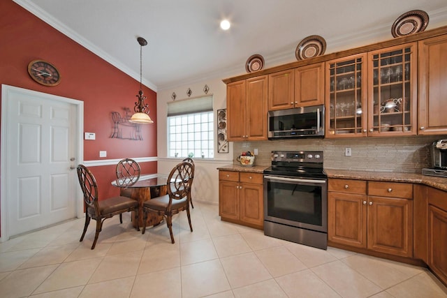 7052 Cataluna Cir, Delray Beach, FL 33446 - kitchen with stainless steel appliances, brown cabinets, ornamental molding, glass insert cabinets, and light stone counters
