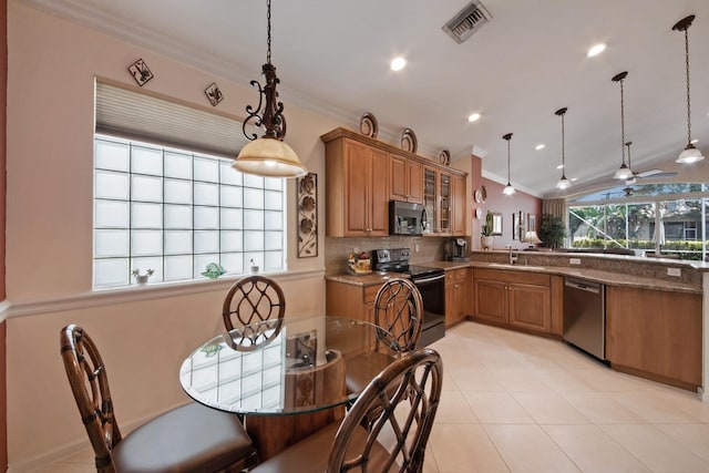 7052 Cataluna Cir, Delray Beach, FL 33446 - kitchen featuring appliances with stainless steel finishes, crown molding, brown cabinets, tasteful backsplash, and glass insert cabinets