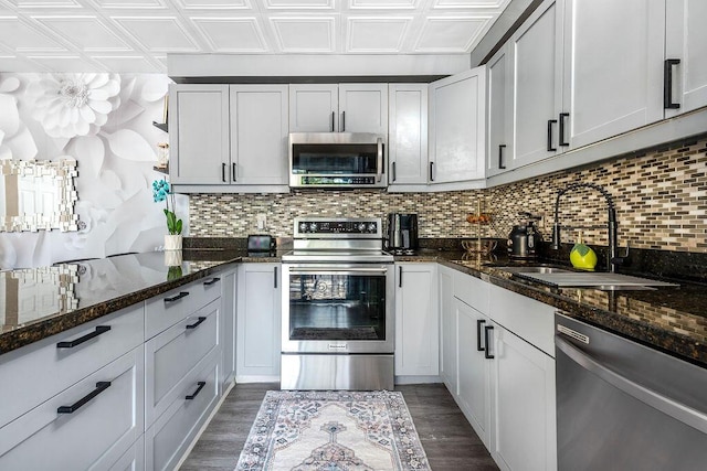 22164 Boca Rancho Dr Unit D, Boca Raton, FL 33428 - kitchen featuring appliances with stainless steel finishes, an ornate ceiling, backsplash, dark stone countertops, and dark wood-style flooring