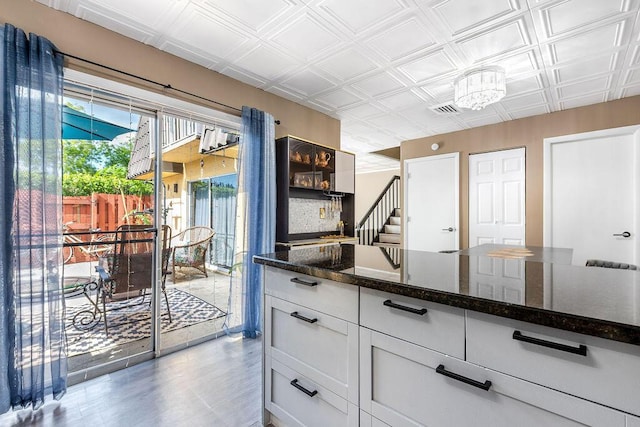 22164 Boca Rancho Dr Unit D, Boca Raton, FL 33428 - kitchen with an ornate ceiling, dark stone counters, light wood-type flooring, and a chandelier