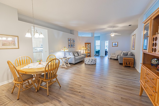 619 NW Monticello Pl, Port Saint Lucie, FL 34986 - dining space featuring wood finished floors, a chandelier, and a ceiling fan