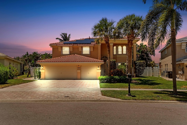 7486 Greenville Cir, Lake Worth, FL 33467 - mediterranean / spanish-style house featuring decorative driveway, a tiled roof, solar panels, and stucco siding