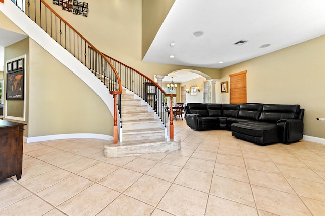 7486 Greenville Cir, Lake Worth, FL 33467 - tiled living room featuring decorative columns, arched walkways, a chandelier, stairs, and recessed lighting