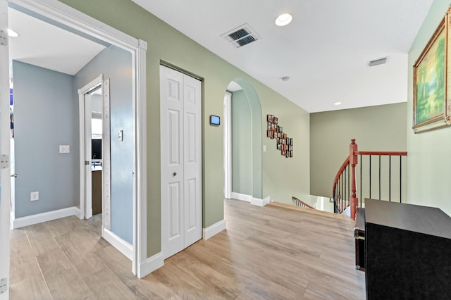7486 Greenville Cir, Lake Worth, FL 33467 - corridor featuring arched walkways, light wood-style flooring, recessed lighting, and an upstairs landing