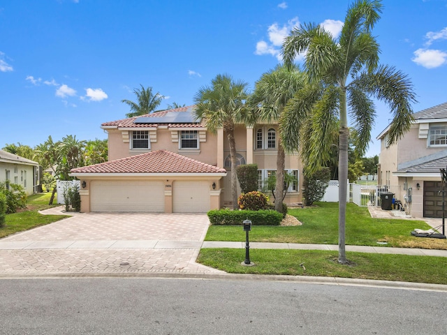 7486 Greenville Cir, Lake Worth, FL 33467 - mediterranean / spanish-style house with stucco siding, roof mounted solar panels, decorative driveway, a tile roof, and an attached garage