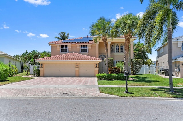 7486 Greenville Cir, Lake Worth, FL 33467 - mediterranean / spanish-style home featuring decorative driveway, roof mounted solar panels, stucco siding, a tile roof, and a garage