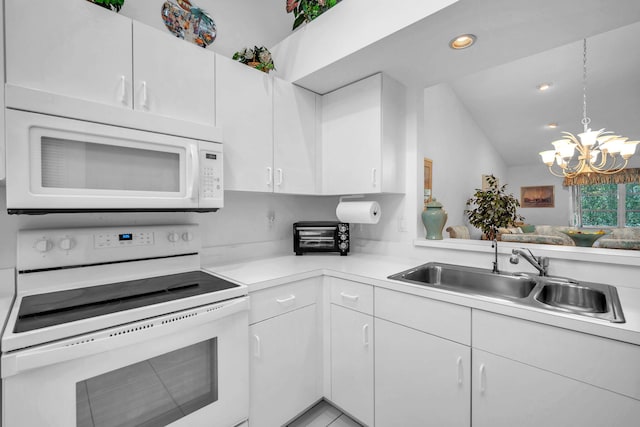 9976 Seacrest Cir Unit D, Boynton Beach, FL 33437 - kitchen featuring white appliances, light countertops, a chandelier, lofted ceiling, and white cabinetry