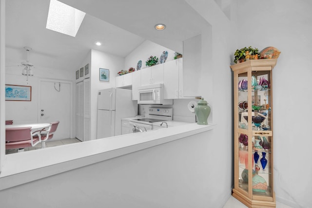 9976 Seacrest Cir Unit D, Boynton Beach, FL 33437 - kitchen with white appliances, a skylight, light countertops, white cabinetry, and recessed lighting