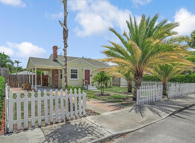 720 N Ocean Breeze, Lake Worth Beach, FL 33460 - view of front of home with a fenced front yard and a chimney