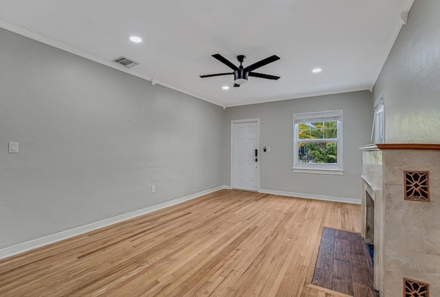 720 N Ocean Breeze, Lake Worth Beach, FL 33460 - unfurnished living room featuring a ceiling fan, light wood-style floors, ornamental molding, recessed lighting, and a tile fireplace