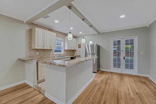 720 N Ocean Breeze, Lake Worth Beach, FL 33460 - kitchen with freestanding refrigerator, light wood finished floors, french doors, tasteful backsplash, and light stone counters