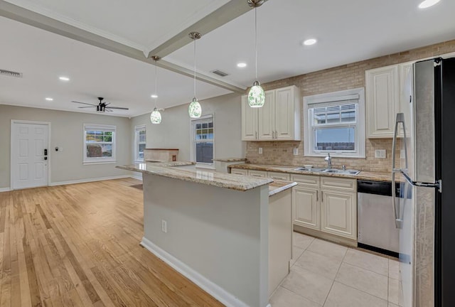 720 N Ocean Breeze, Lake Worth Beach, FL 33460 - kitchen featuring appliances with stainless steel finishes, light stone countertops, decorative backsplash, a kitchen island, and decorative light fixtures