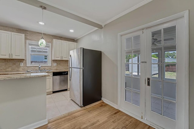 720 N Ocean Breeze, Lake Worth Beach, FL 33460 - kitchen featuring appliances with stainless steel finishes, ornamental molding, backsplash, white cabinets, and light wood finished floors