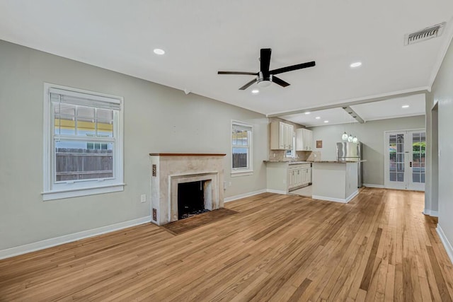 720 N Ocean Breeze, Lake Worth Beach, FL 33460 - unfurnished living room with plenty of natural light, light wood-style floors, a ceiling fan, a fireplace with flush hearth, and recessed lighting